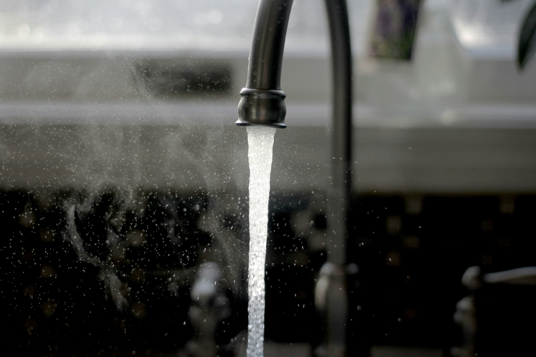Heißes Wasser fließt in eine Küchenspüle